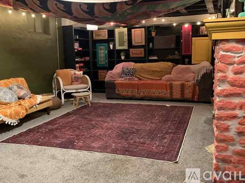 A living room with a couch, chair, and rug.