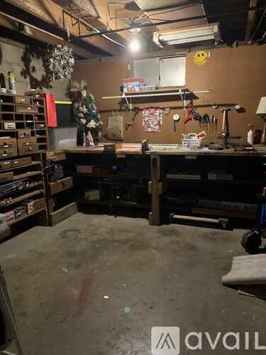 A workshop with a workbench, tools, and a fan.