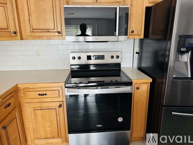 A kitchen with a stove, microwave, and refrigerator.