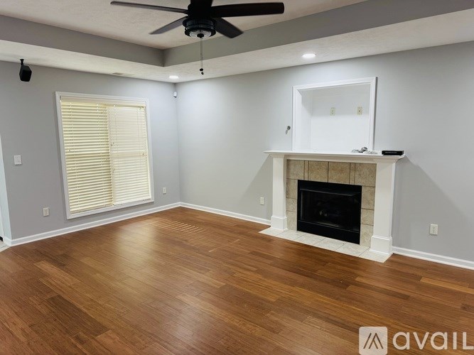 A room with a fireplace and a ceiling fan.