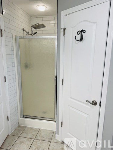 A white door with a handle and a decorative knob is closed.