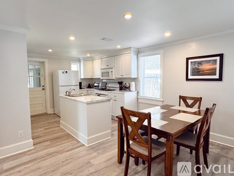 A kitchen with a table and chairs in the foreground.