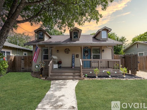 A house with a front yard and a flag on the porch.