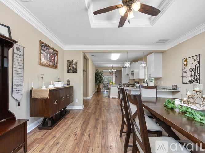 A well-lit kitchen and dining area with wooden floors and furniture.