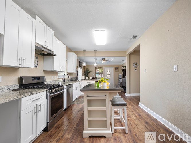 A kitchen with white cabinets and a wooden island.
