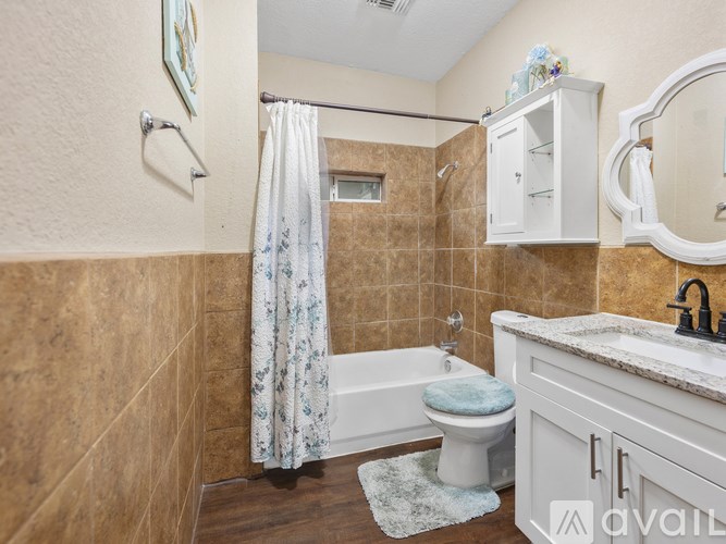 A bathroom with a toilet, sink, and shower.