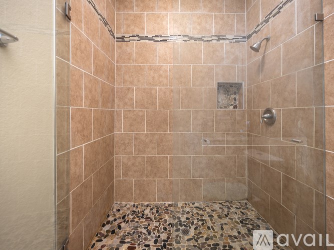 A tiled shower with a mosaic floor.