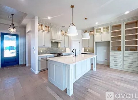 A spacious kitchen with white cabinets and a central island.