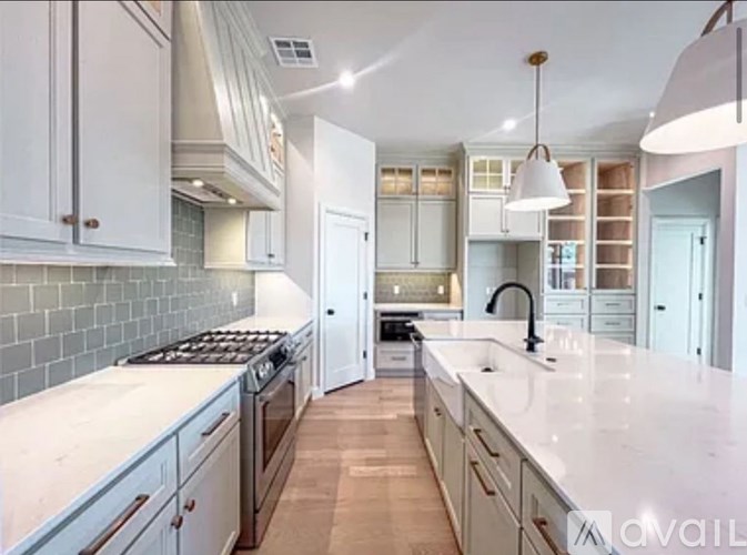 A kitchen with white cabinets and a marble countertop.