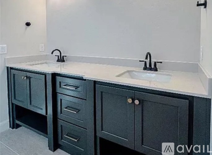 A bathroom with two sinks and dark cabinets.