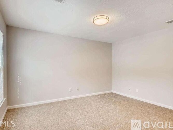 A room with a carpeted floor and a ceiling fan.