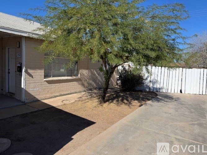 A house with a white fence and a tree in the yard.