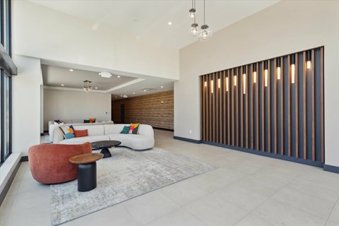 A modern living room with a white sofa and a wooden panelled wall.