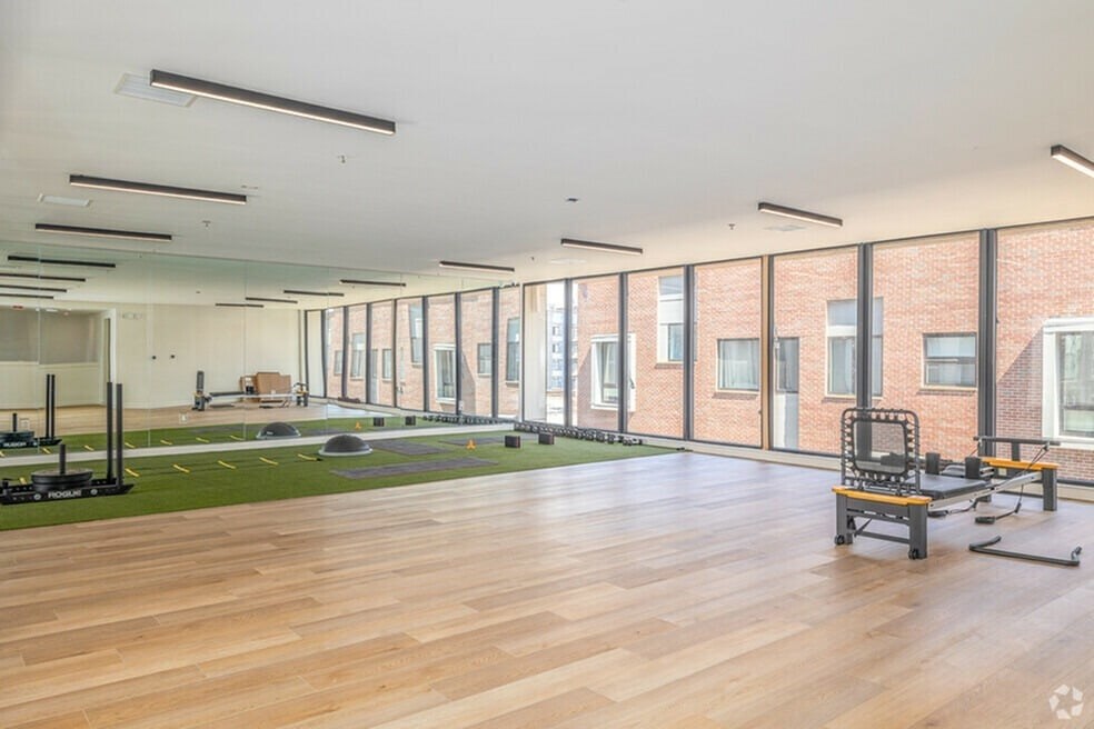 A gym with a green mat and weights.