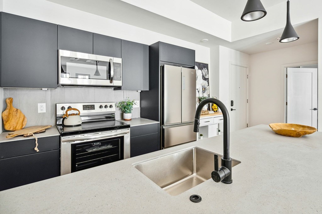 A modern kitchen with a stove, oven, and sink.