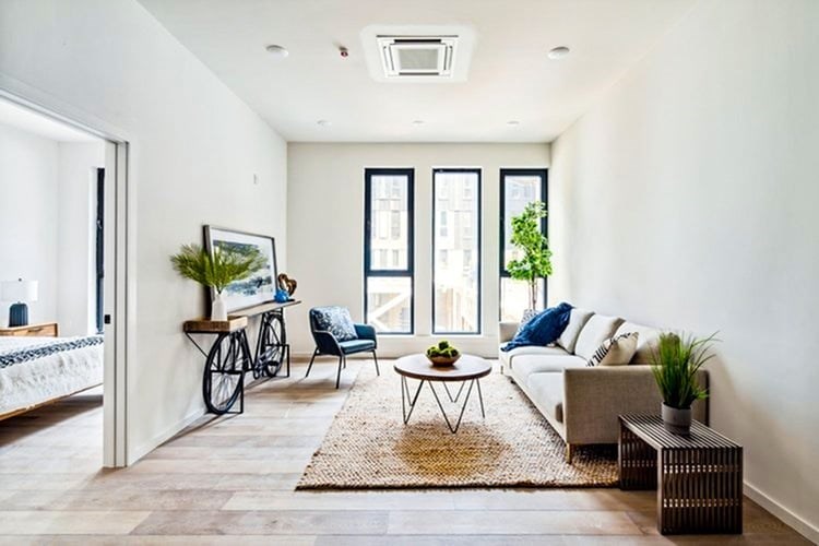 A living room with a couch, a chair, a coffee table, and a bicycle.