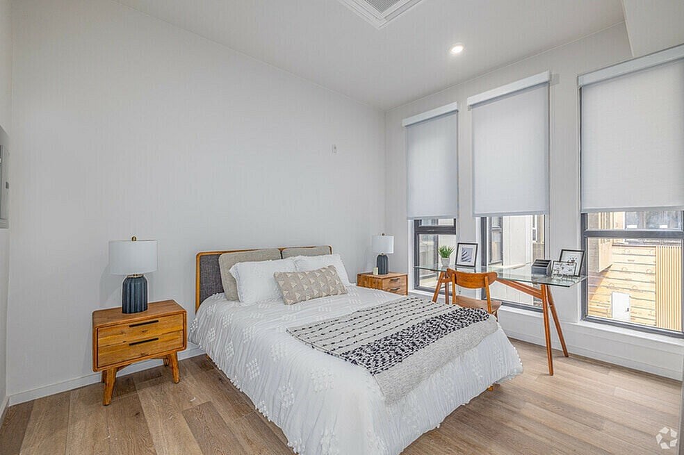 A bedroom with a bed, nightstand, and chair.