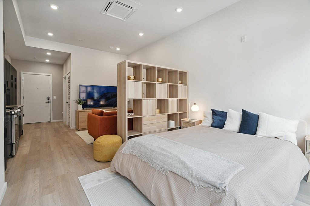 A bedroom with a large bed and a TV in the corner.