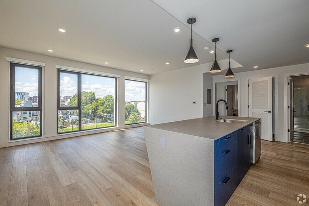 A modern kitchen with a large island and wooden floors.