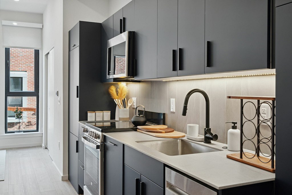 A modern kitchen with dark cabinets and a stainless steel dishwasher.
