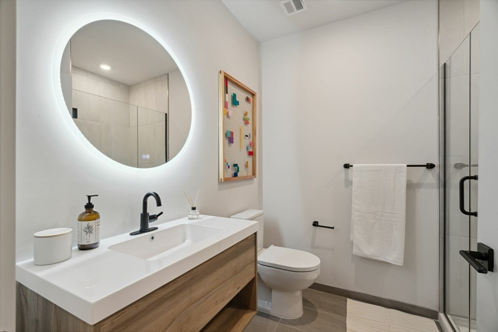 A bathroom with a white sink and toilet.