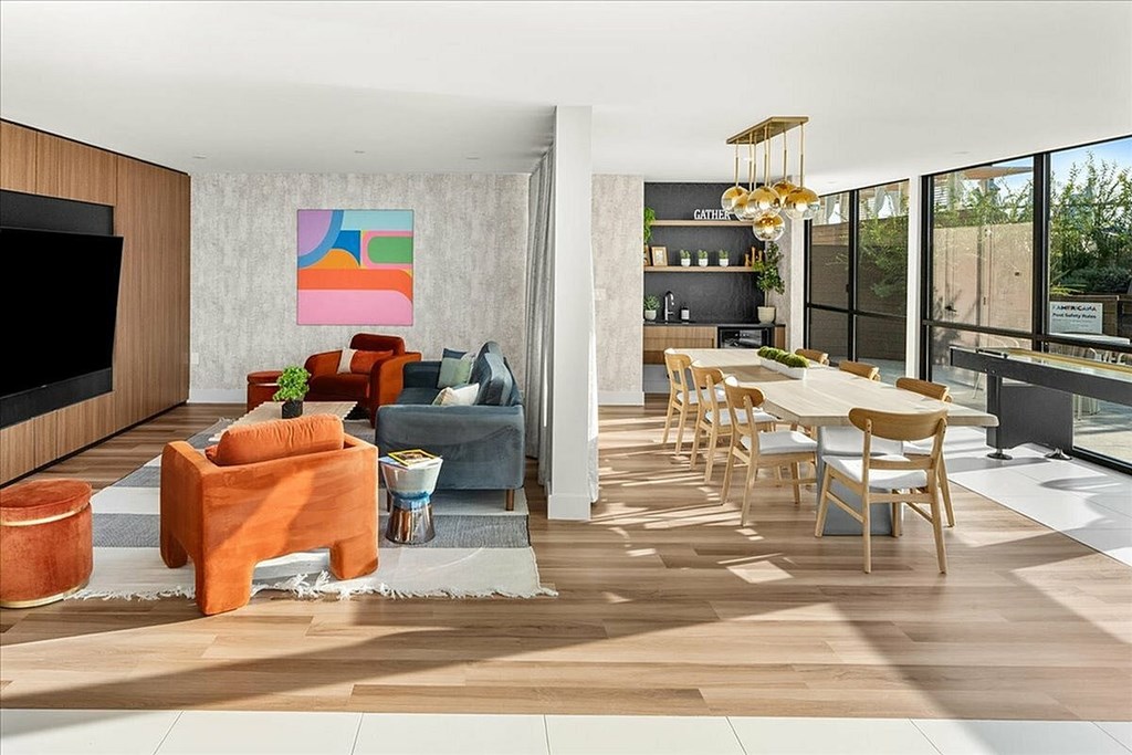 A modern living room with a television, sofas, and a dining table.