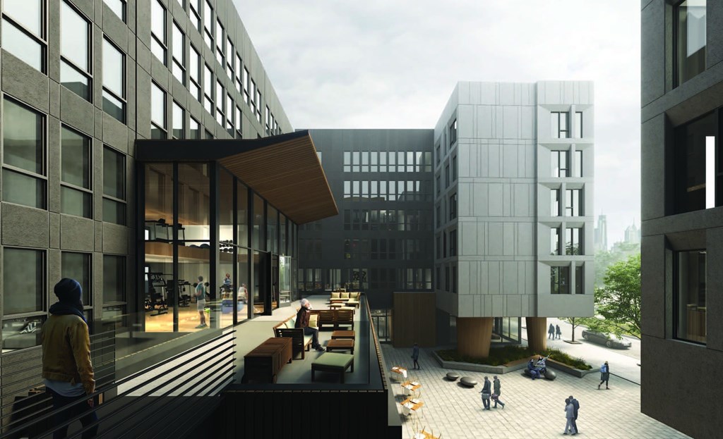 A person in a yellow hoodie is sitting on a bench in a courtyard surrounded by buildings.