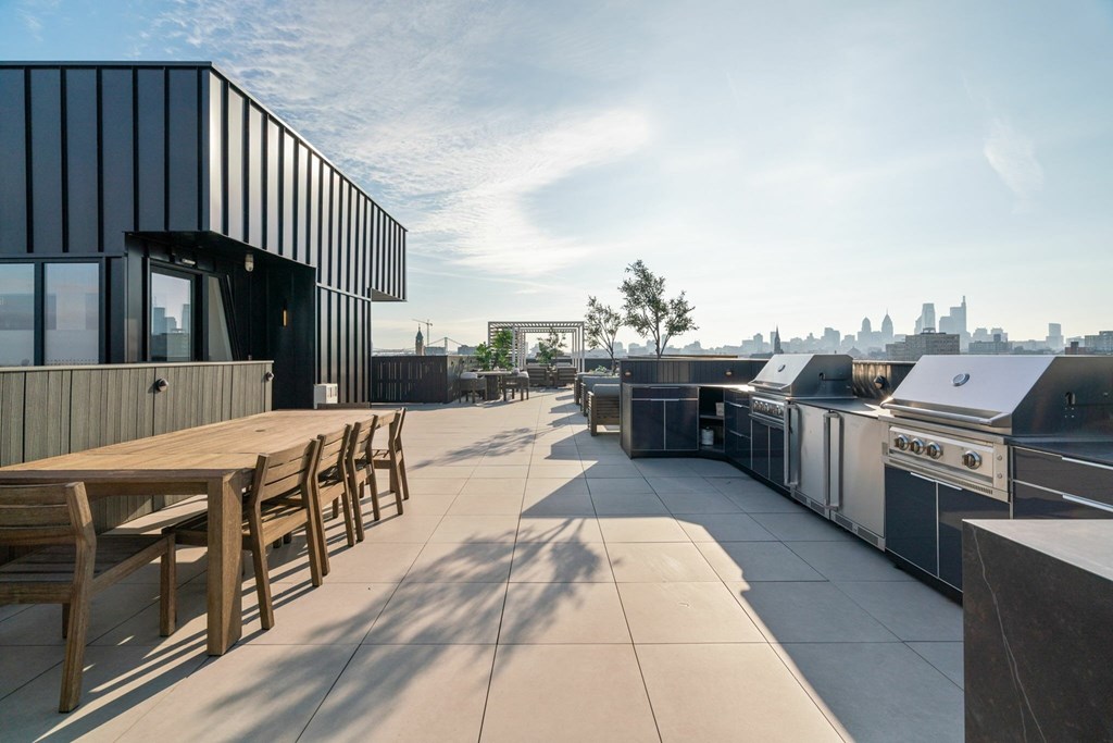 A modern building with a wooden table and chairs on the patio.