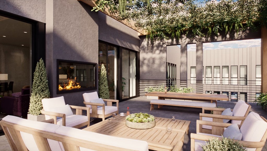 A modern outdoor seating area with a fireplace and potted plants.