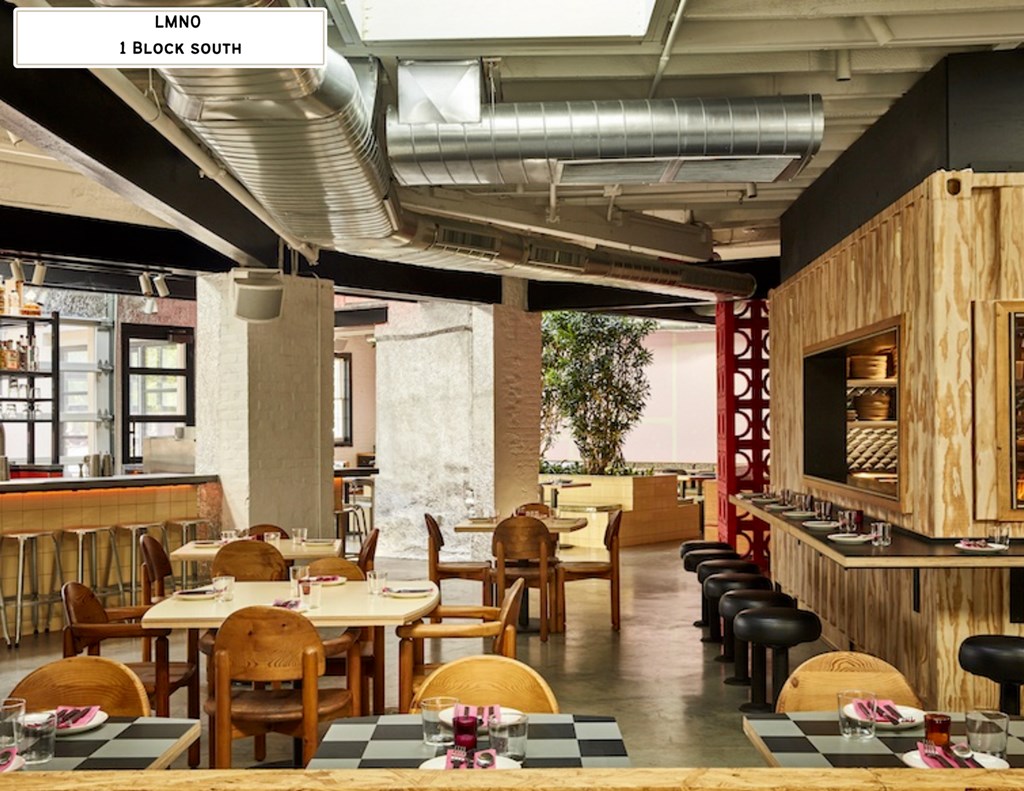 A restaurant with wooden tables and chairs and a bar area.