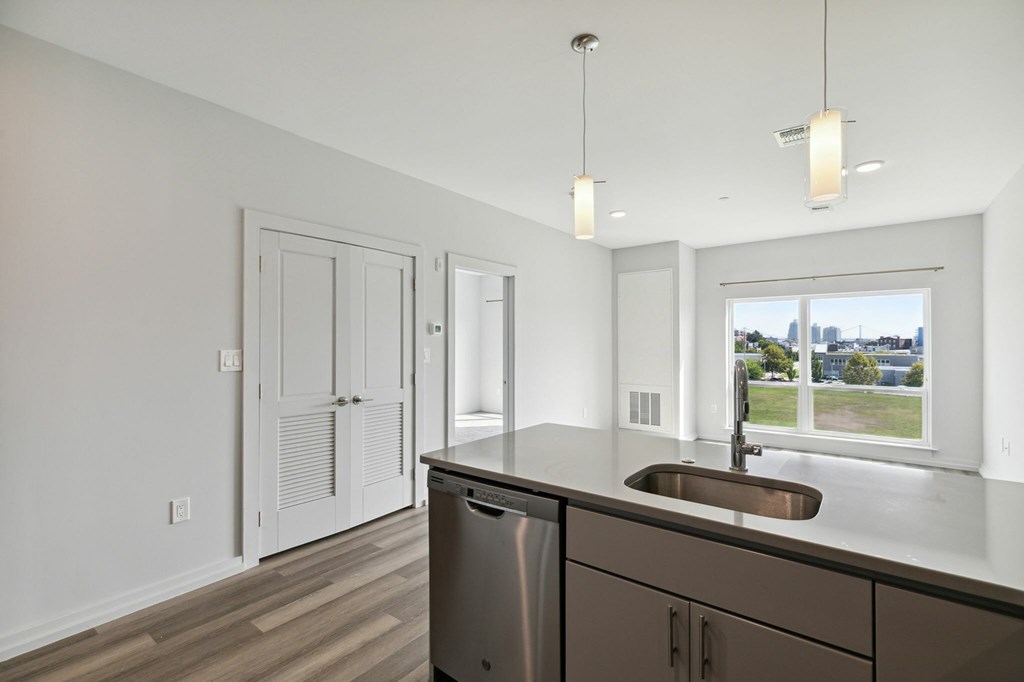 A kitchen with a stainless steel sink and cabinets.