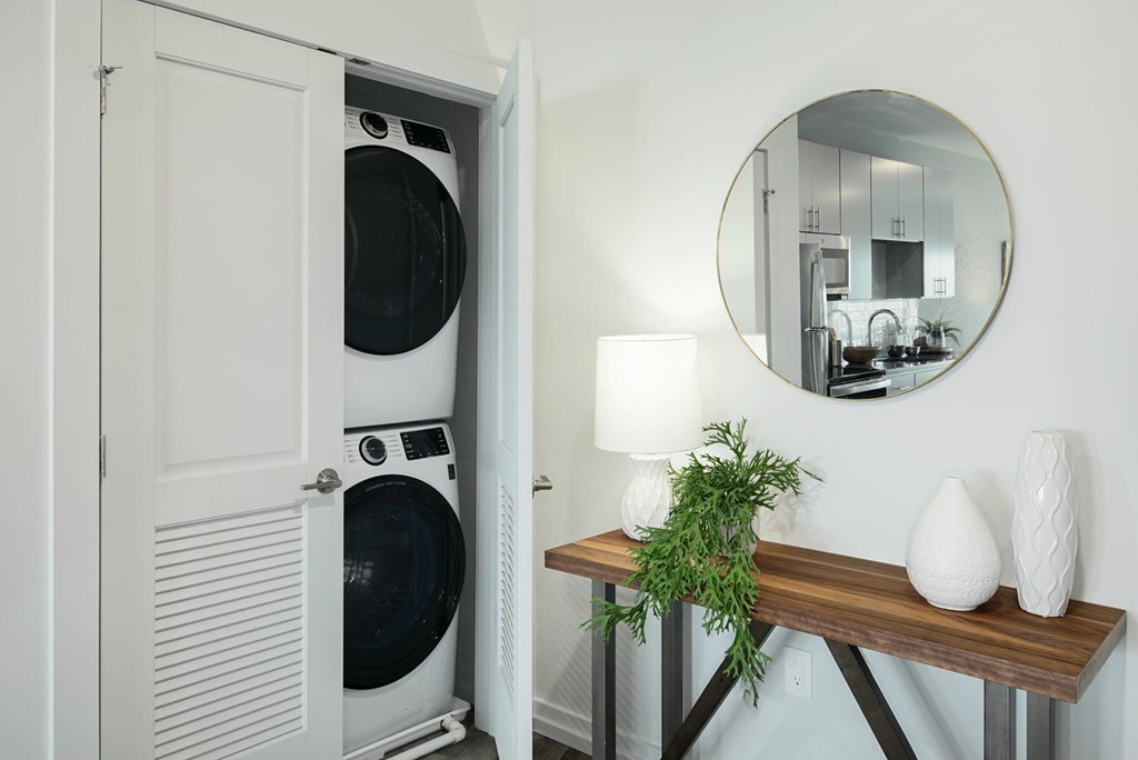 A white washing machine is in a white cabinet.