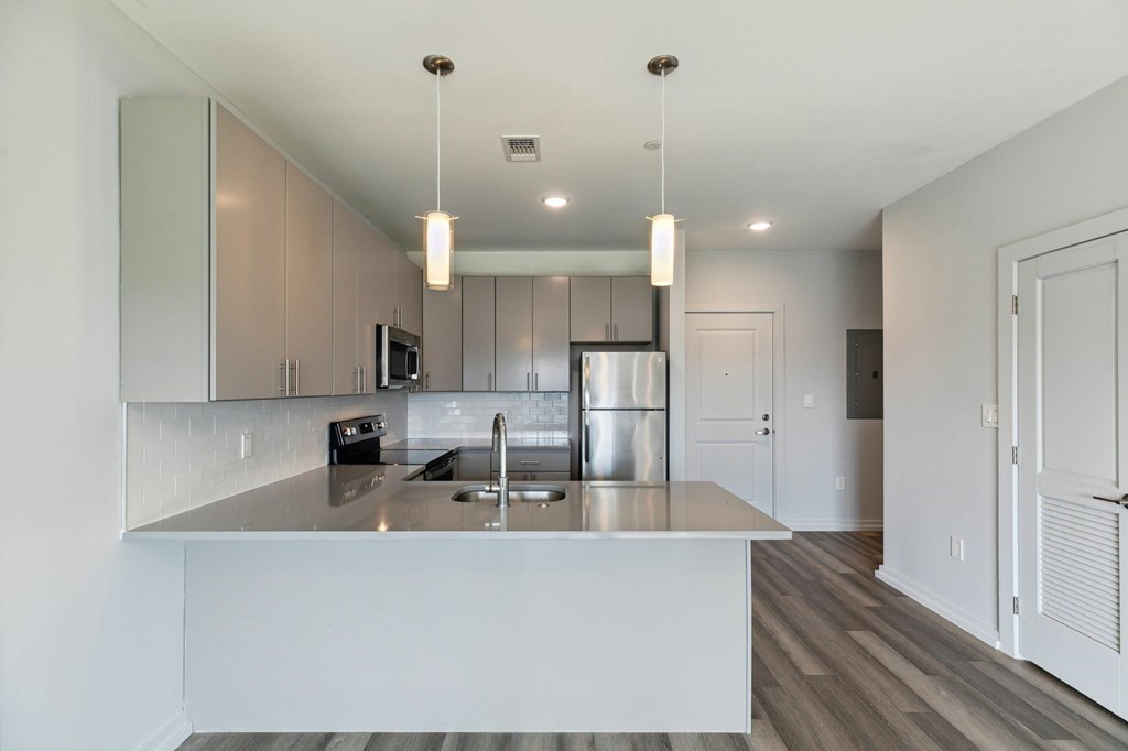 A modern kitchen with a stainless steel sink and refrigerator.