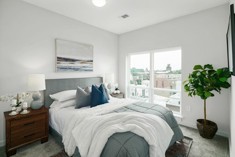 A bedroom with a large bed and a painting on the wall.