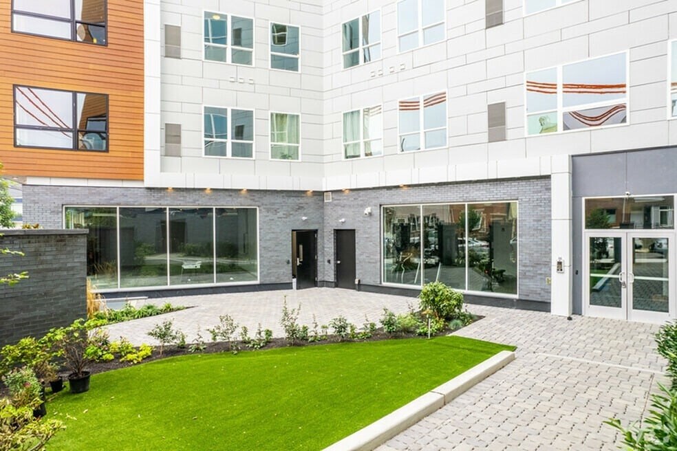 A modern building with a green lawn in front.