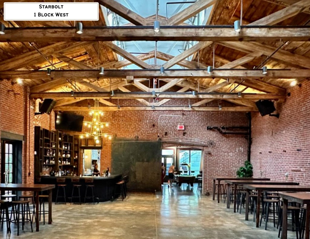 A large open space with tables and chairs and a brick wall.