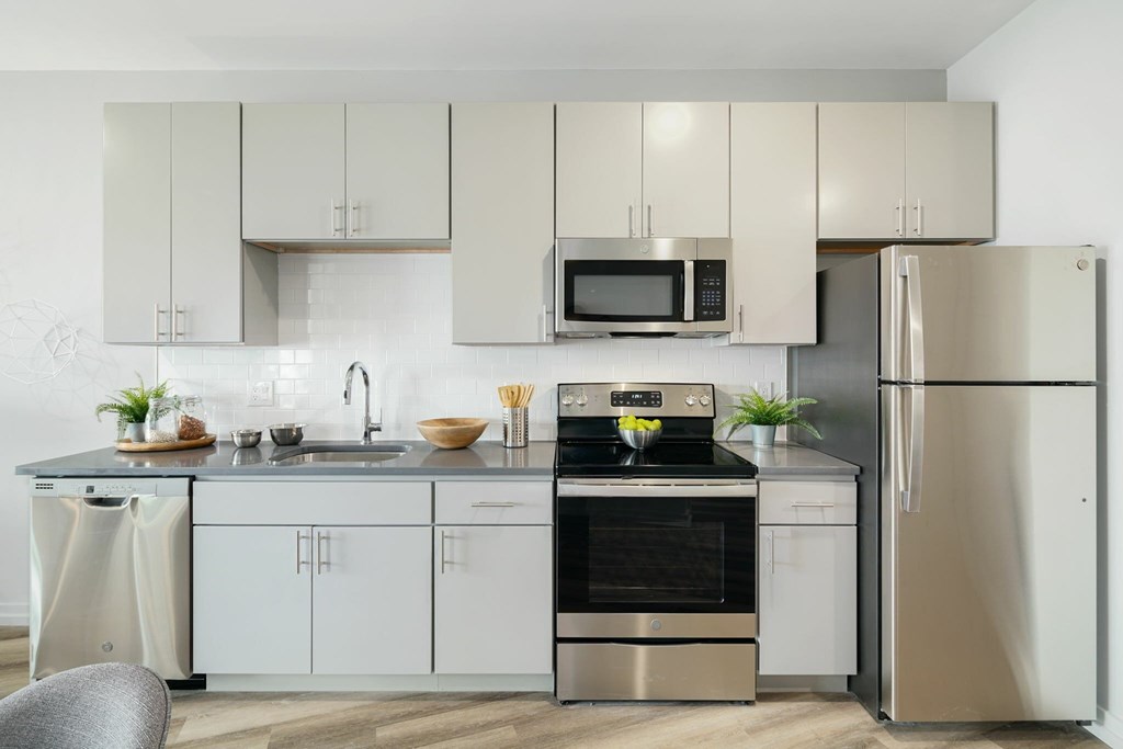 A modern kitchen with stainless steel appliances and white cabinets.