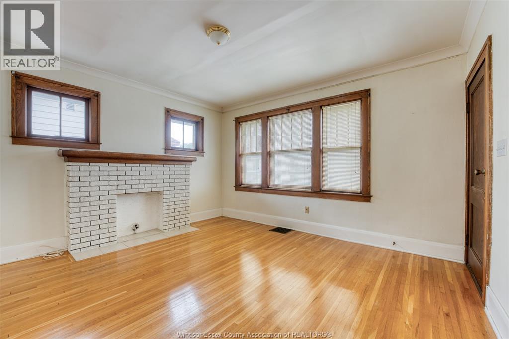 A room with a fireplace and wood flooring.