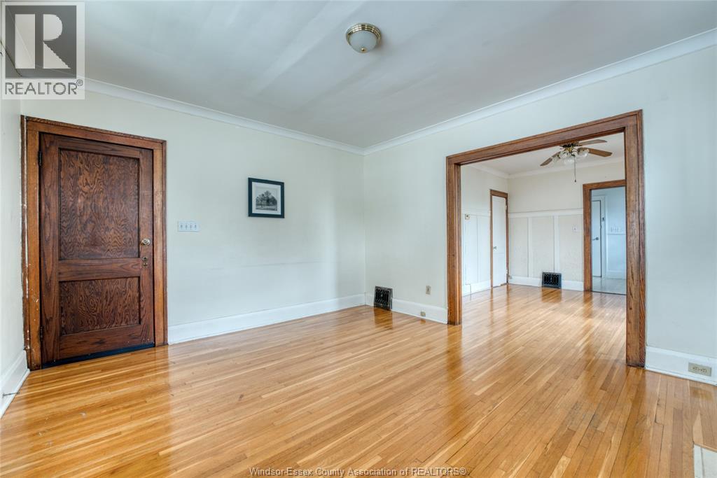 A room with wooden floors and a large mirror on the wall.