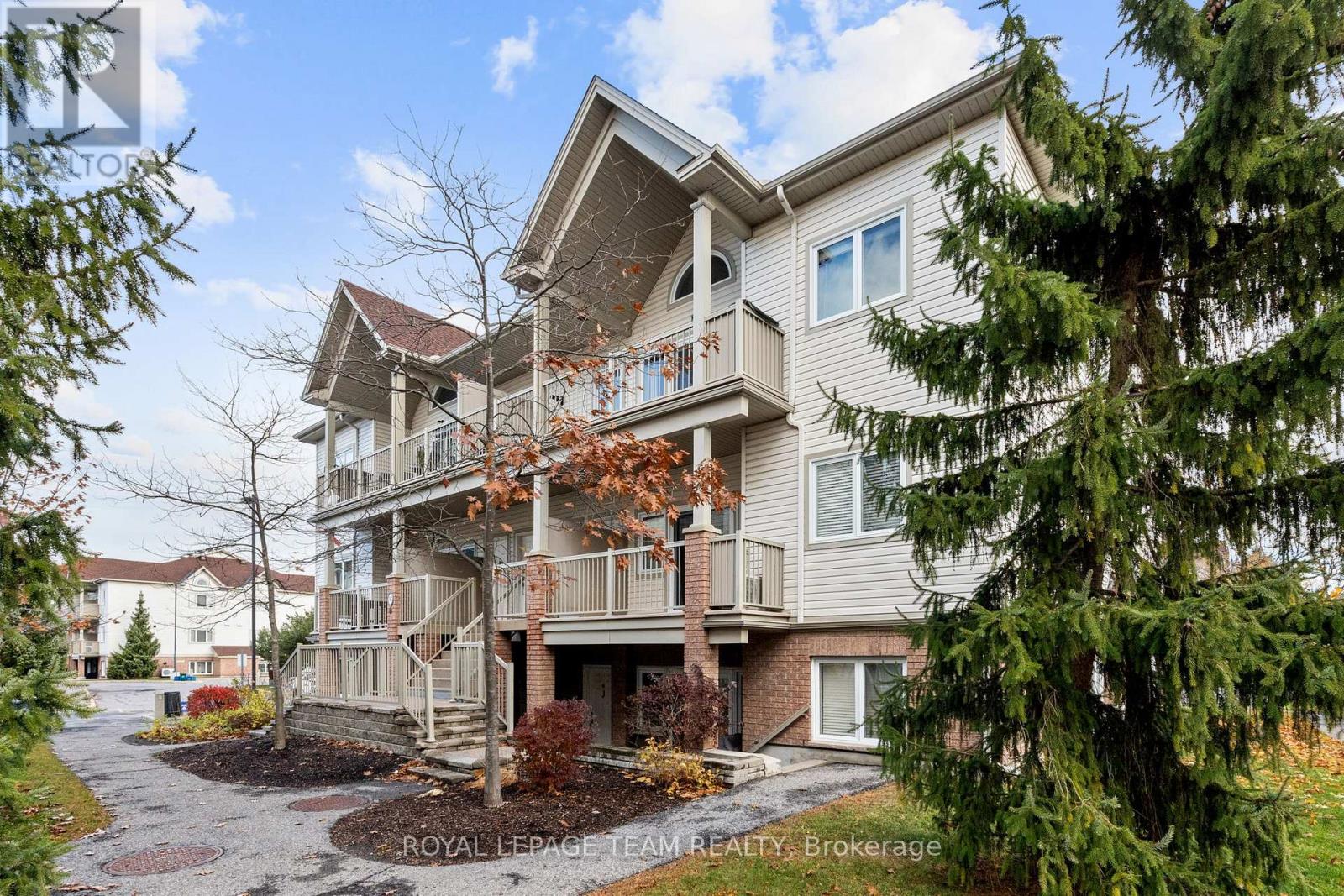 A multi-story residential building with a balcony and a small garden in front.