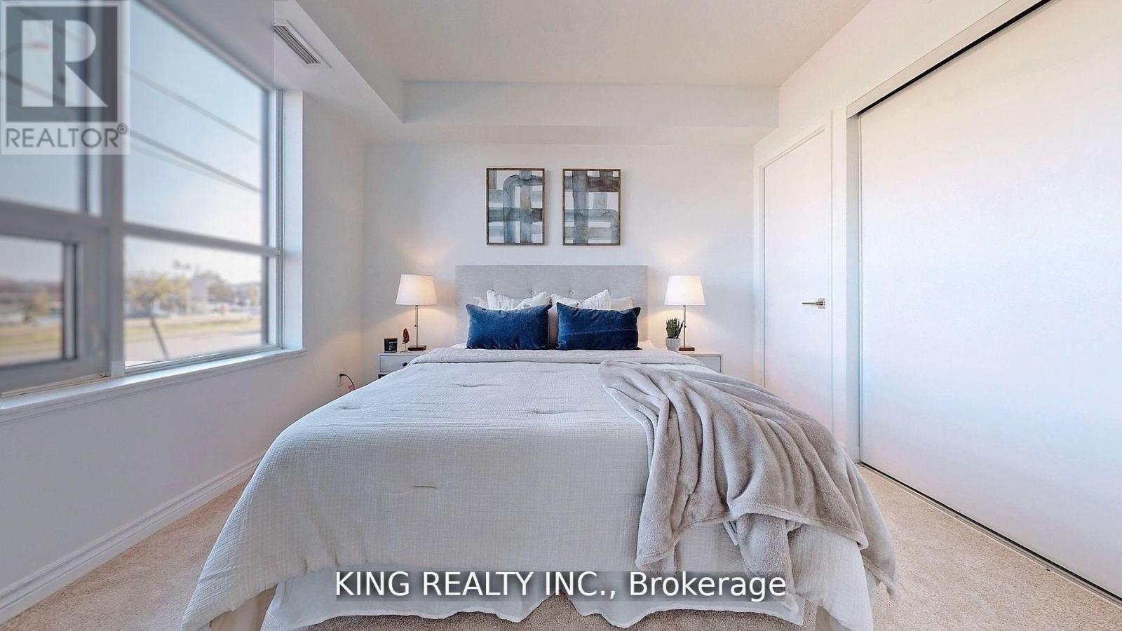 A bedroom with a large bed and a window overlooking a landscape.