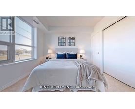 A bedroom with a large bed and a window overlooking a landscape.
