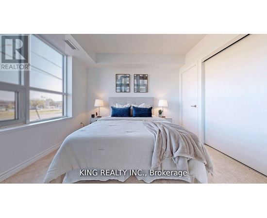 A bedroom with a large bed and a window overlooking a landscape.