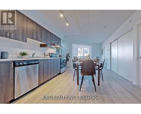 A modern kitchen with a dining table set for two.
