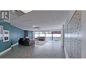 A spacious room with a row of lockers on the wall and a couch in the middle.