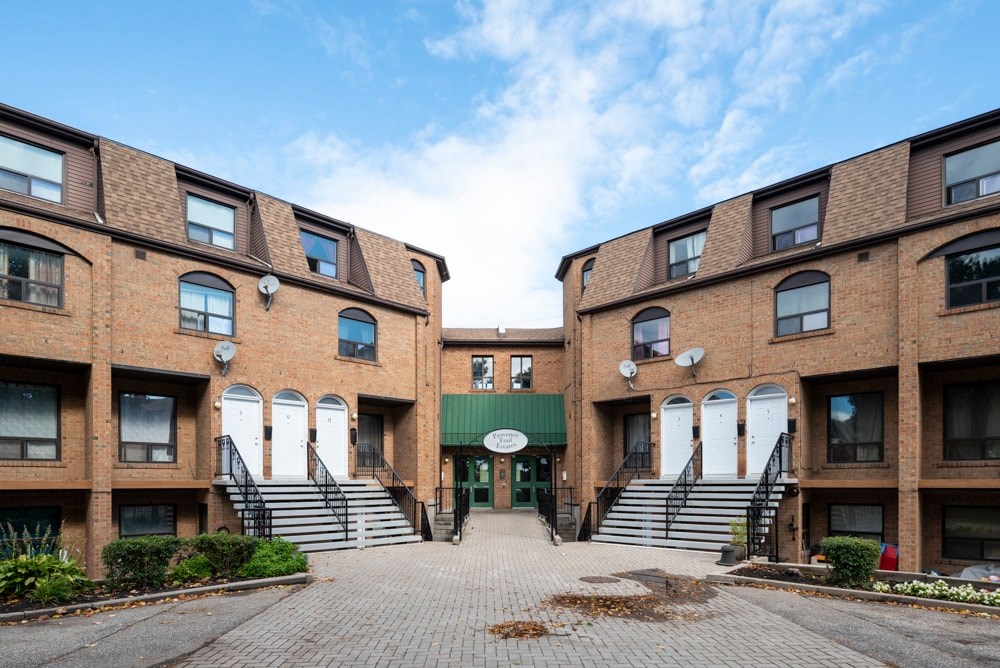 A brick building with a green awning and white doors.