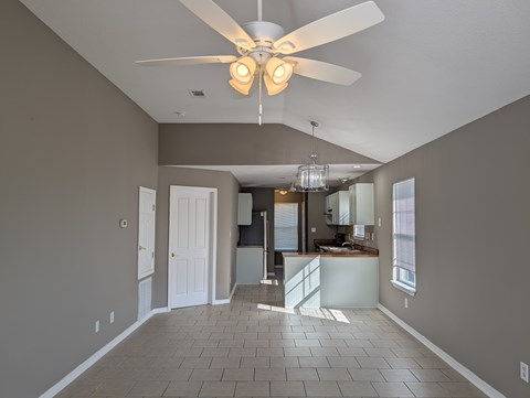 A spacious room with a ceiling fan and tiled flooring.