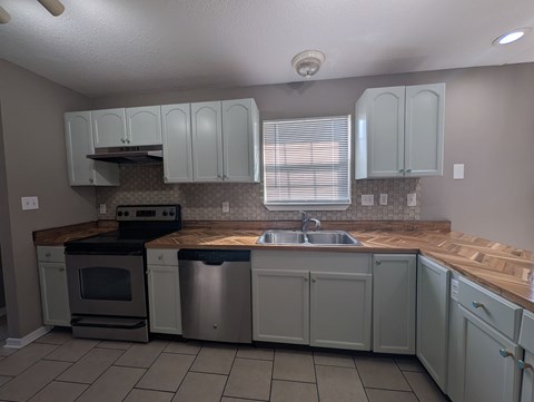 A kitchen with a stove, oven, and sink.