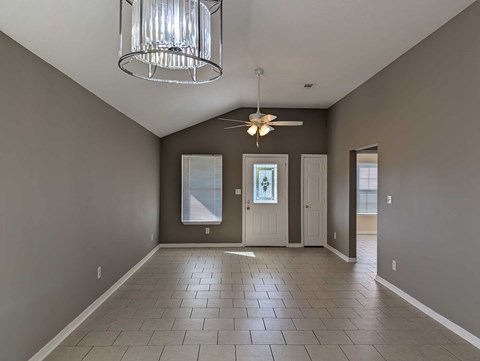 A room with a ceiling fan and a chandelier.