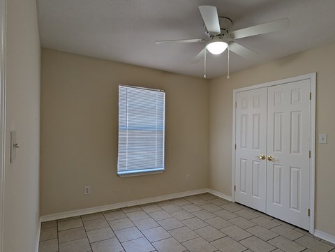 A room with a ceiling fan and a door.